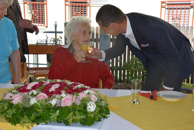 Direktor Johann Deinhofer stoßt mit einem Glas Sekt zum Geburtstag an.
