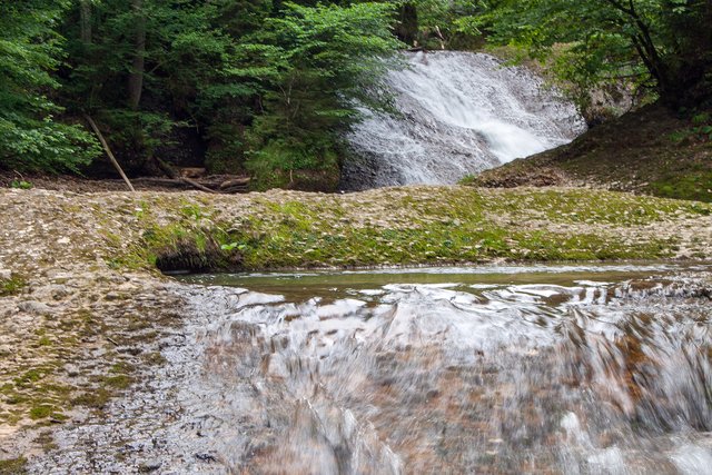 Ein Klick in das Foto öffnet die Galerie im Vollbildmodus.
Bild 37: Direkt oberhalb der Wasserfälle über den Kaskaden sind mehrere Strudellöcher zu sehen. Hier ein größeres Strudelloch mit dem Großen Wasserfall der Station 4 im Hintergrund.
