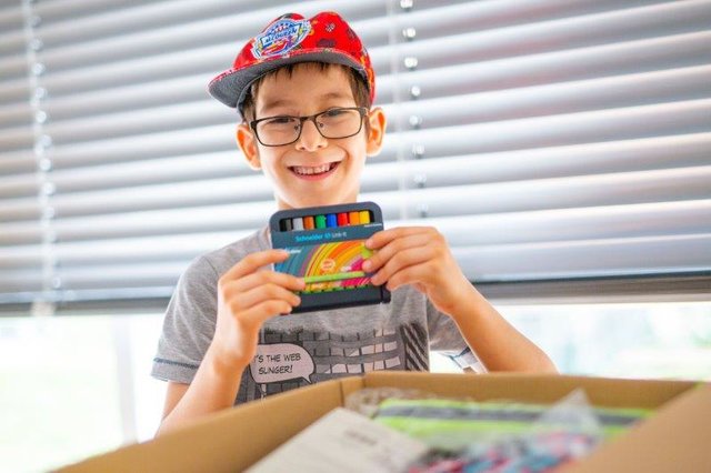 Adam ist 7 Jahre alt und glücklicher Besitzer eines Schulstartpaketes Nummer 9. Darin enthalten ist z. B. ein Rucksack, ein Schreibset, ein Federpenal und eine Jausenbox. Diese gefällt Adam am besten.