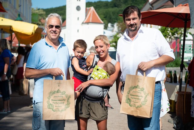 Stadtrat Harald Wolkerstorfer, Marktbesucherin Agnes Klugmayer mit ihren Söhnen und Bürgermeister Stefan Steinbichler.