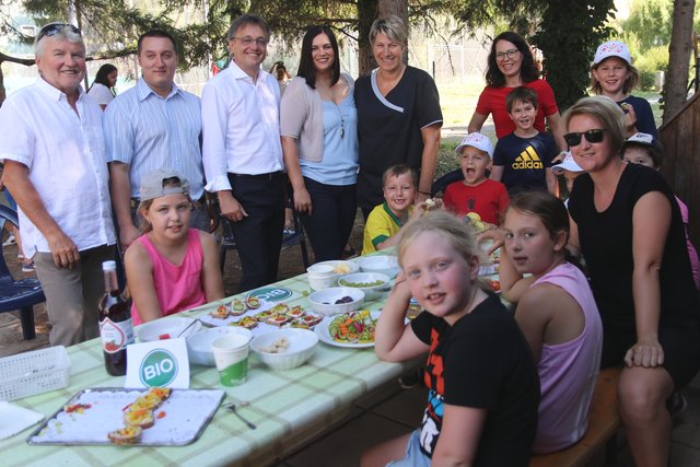 Energie Burgenland Betriebsratsvorsitzender Hartwig Roth, Betriebsrat Bernd Weiss, Energie Burgenland Vorstandsvorsitzender Michael Gerbavsits, Landesrätin Astrid Eisenkopf und Personalchefin Beate Bauer-Zinggl mit den Kindern des Tenniscamps bei der gesunden Bio-Jause, die von der Energie Burgenland Küchenmannschaft rund um Petra Steiner zubereitet wurde.