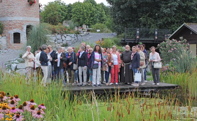 Die Samareiner Goldhaubenfrauen mit Pater Werner beim Teich im Klostergarten Pupping.