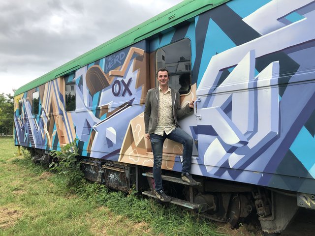Geschäftsführer des Vereins Bahnfrei, Markus Tobolka, vor einem der farbenfrohen Waggons in Höhe des Vereinslokals.  | Foto: Sellner