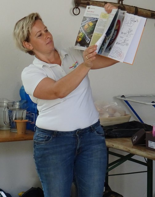 Anita erklärt das Bemalen der Kieselsteine aus der Donau.