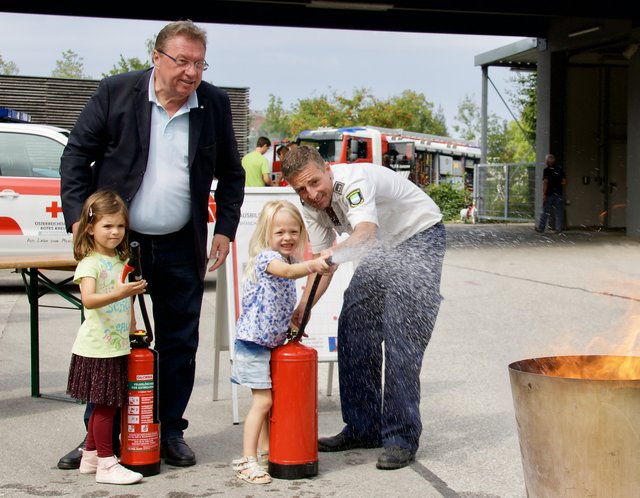Bürgermeister Andreas Stockinger und Oliver Inzinger (Organisator des Thalheimer Blaulichttages) zeigten den Kindern wie man Feuer richtig löscht.