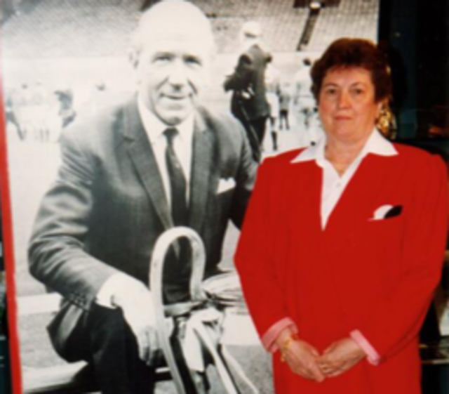Anna Kaufmann vor dem Bild von Sir Matt Busby.