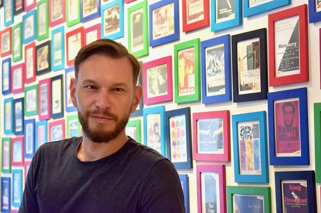 Gerd Wilfing im bunten Foyer des Theaterzentrums: Dort hängen alle Vorstellungen der letzten Jahre.