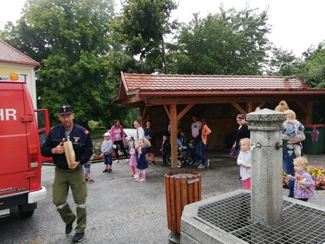Feuerwehrkommandant Christian Magnet holt die Bambinis mit dem großen roten Feuerwehrauto im Pfarrhof ab