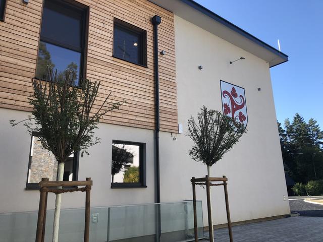 Das Gemeindewappen strahlt an der Fassade.