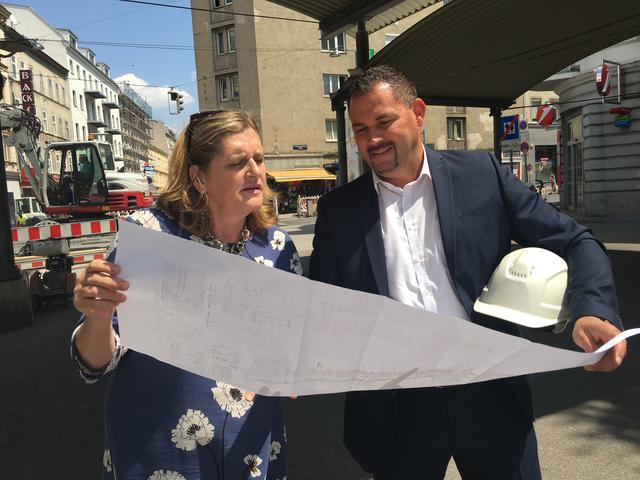Bezirkschefin Susanne Schaefer-Wiery und Helmut Meixner, Wiener Netze, begutachten die Pläne zu den Bauarbeiten.
