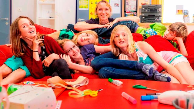 Rainbows Gruppe und Gruppenleiterin am Sofa liegend.