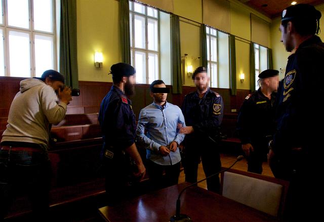 Der Tatverdächtige, flankiert von Justizwachebeamten.