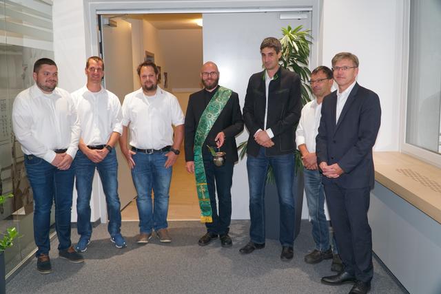 Mitarbeiter und firmenleitung bei der Segnung der Anlage.