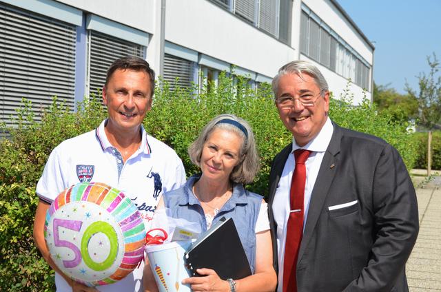 Helmut Grimm, einer der Schüler der ehemaligen 1b Georg-Bilgeri-Straße von 1969, mit der aktuellen Direktorin Karin Kadoch und Bezirksvorsteher Ernst Nevrivy.