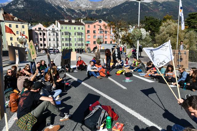 Im Sitzkreis blockierte die Gruppe „Extinction Rebellion Innsbruck“ ab 12:05 Uhr den Verkehr zwischen Altstadt und Mariahilf. Die TeilnehmerInnen riefen zu Maßnahmen gegen die Erderwärmung auf.  | Foto: zeitungsfoto.at