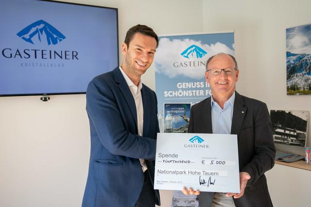 Gasteiner Mineralwasser-Geschäftsführer Walter Scherb und Peter Rupitsch, Direktor des Vereins der Freunde des Nationalparks Hohe Tauern, bei der Übergabe des Spendenschecks für das Artenschutzprojekt Urforelle.