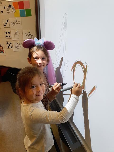Buchstaben am Smartboard schreiben: Charlotte und Magdalena.