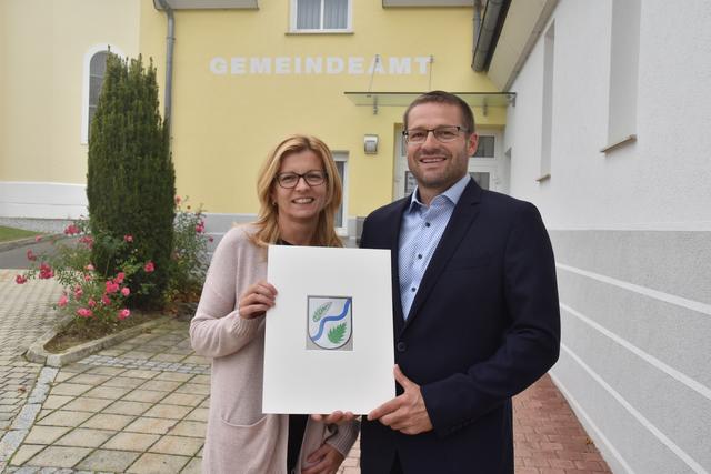 So schaut das neue Wappen aus, das Bürgermeister Jürgen Kurta und Gemeindemitarbeiterin Barbara Recker zeigen.