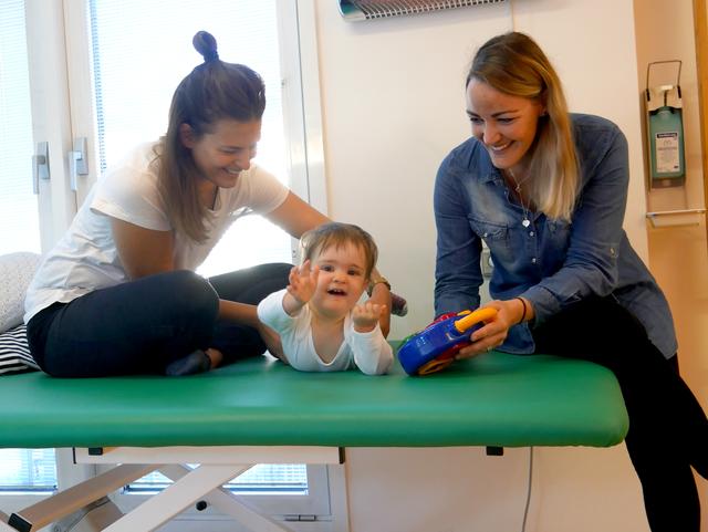 Physiotherapeutin Nora Freitag und Mutter Ines Bachmann machen mit Lilly-Marie verschiedene Übungen.