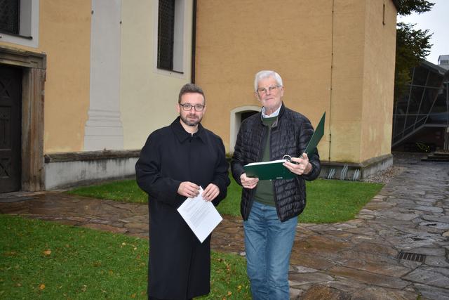 Pfarrer István Holló (r.) und Josef Reiterer, Vorsitzender des pfarrlichen Wirtschaftsrates, vor der sanierungsbedürftigen Stadtpfarrkirche in Deutschlandsberg.