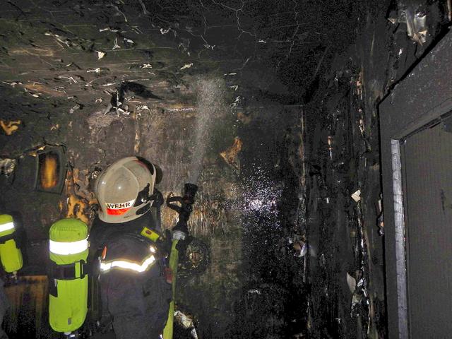 Ein Feuerwehrmann beim Löschen in der Wohnung.