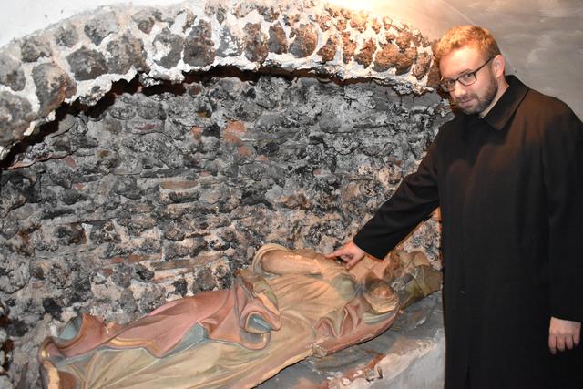 Pfarrer István Holló zeigt auf die Schäden an der Pestheiligen Rosalia.