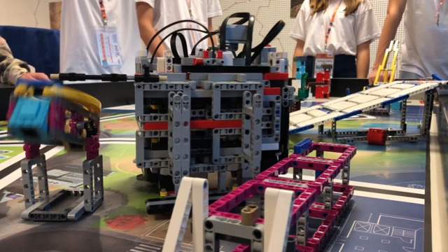 Wenn der Roboter (Mitte) korrekt ausgerichtet ist, löst er bei der Station (links im Bild) den Kippmechanismus aus. | Foto: Rüggeberg