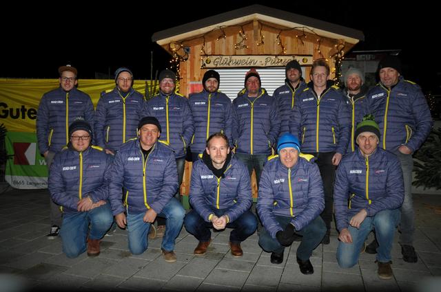 Der Freizeitverein Road Crew Strallegg in den neuen Vereinsjacken vor einer der fünf neuen Ausschankhütten aus Lärchenholz.