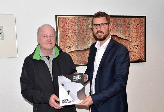 Helmut Wagner überreicht sein frisch gedrucktes Buch an Bgm. Christian Härting.