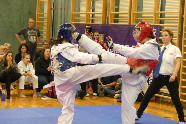 2019-11-24-TangunClubmeisterschaft-Kyorugi-KicanovicSuzana-vs-NovakovicNikolina
v.l.n.r: in Blauer Schutzweste Suzana Kicanovic mit Pandal-Chagi gegen Nikolina Novakovic in roter Schutzwest die Dolyo-Chagi kickt