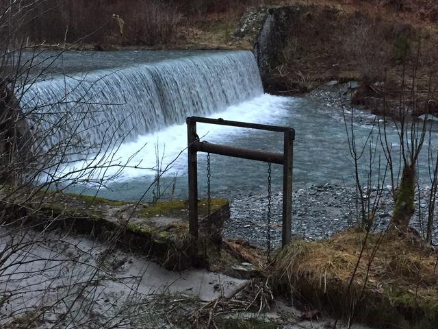 Blick vom ersten Teilstück des Mühlbachs, nunmehr privatisiert, in Richtung Wasserfall. Es ist deutlich erkennbar, dass die kleine Wehranlage außer Funktion ist und repariert werden muss, da sonst Wasser, das in den Mühlbach geleitet wird, sofort wieder abfließt.