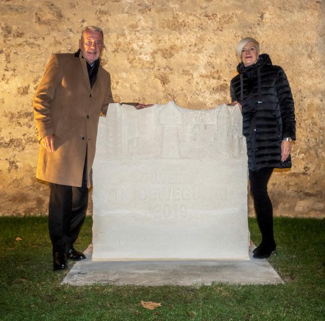 Bürgermeister Klaus Schneeberger und Judith Hönig präsentieren den "Welt in Bewegung"-Stein an der Stadtmauer.