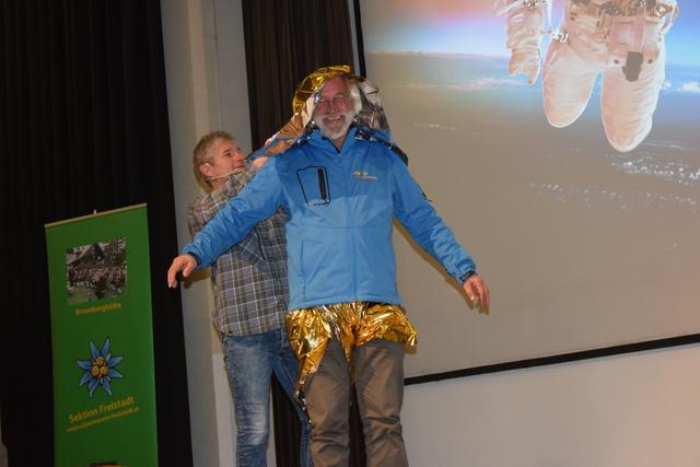 Alpenvereinsobmann Gerd Simon wird vom Vortragenden Michael Larcher in einer Rettungsdecke verpackt  | Foto: Martin Reindl