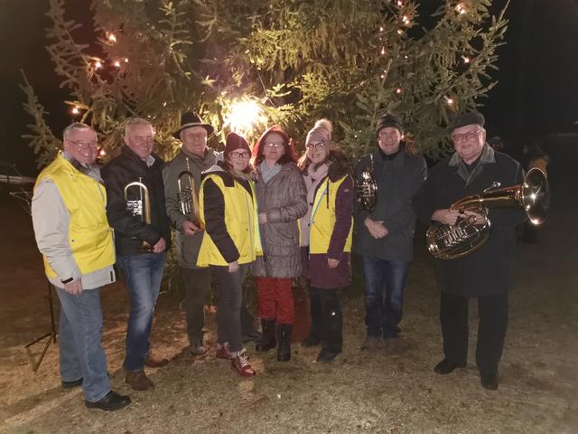 Beim Weihnachtsbaum, der dieses Jahr von Gerhard Hofböck gespendet wurde, trafen sich StR Karl Pölzelbauer (links), GR Brigitta Ulreich (Bildmitte), Nadine Flieger (4. von links), Yvonne Eichberger (6. von links) und GR Franz Fidler (3. von links) mit seinen Musikanten.