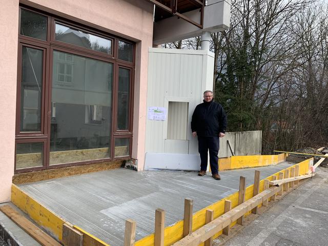 Bürgermeister Michael Göschelbauer vor dem zukünftig barrierefreien Eingang der Bäckerei und dem neuen Bankomaten