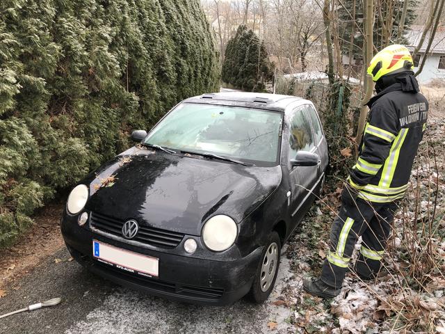 Feuerwehrmitglieder bei der rutschigen Fahrzeugbergung in der Berggasse.