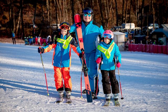 Skilehrer Gerhard "Faxe" Striednig mit Valentin und Johanna Kopeinig