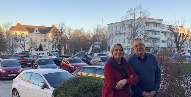 Dr.in Eva Mückstein und "Comebacker" Dr. Ernst Tiefengraber vor der Blechwüste am Schlossplatz, im Hintergrund das schlössliche Rathaus. Die Grünen wollen ein autofreies Zentrum, ein machbares Konzept wurde von der TU Wien bereits vorgelegt.