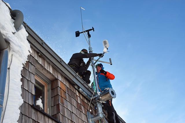 Die Experten des Lawinenwarndienstes Tirol bei der Montage der Windstation am Dach der Erzherzog-Johann-Hütte.