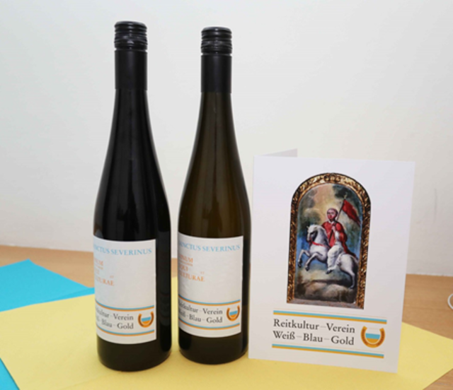 Reitkultur-Verein Weiß-Blau-Gold. Der neu kreierte Vereinswein "Sanctus Severinus" zu Ehren des Rosses und der Kultur. Auf dem Titelblatt des Festprogrammes ist der heilige Severin von Noricum hoch zu Ross abgebildet.