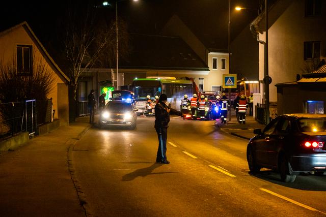 Einsatzkräfte der Freiwilligen Feuerwehr Kierling transportieren das Unfallfahrzeug. Die Polizei regelt den Verkehr.