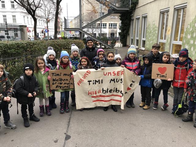 "Unser Freund Timi muss hier bleiben!", steht auf dem Transparent. Timi steht mit seiner pinkfarbenen Haube ganz in der Mitte.