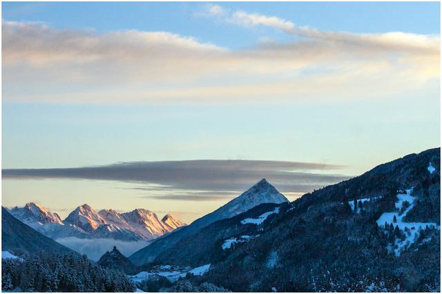 Bild 01: Blick nach Osten. Die Mieminger Kette ist bereits von der aufgehenden Sonne beleuchtet. Fernsicht bis zu den Bergen von Telfs (ca. 50 km). Links unten ist die Kronburg noch im tiefen Schatten. Auch der Tschirgant (2.370 m) liegt noch im tiefen Schatten. Rechts sieht man die N-O- Flanke des Krahbergs (Schigebiet Venet) mit Abschnitten der "Rifenalabfahrt".
