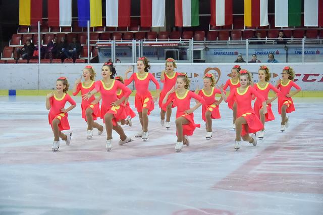 Mit Eleganz und Grazie lassen die Eisläuferinnen und Eisläufer aus dem Chaos Bilder auf der Eisfläche entstehen.