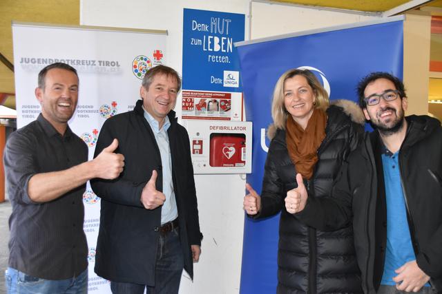Leben retten mit dem Defi: Derd Pertunaj (Haustechniker), Georg Klammer (Direktor WRG), Carmen Kurz (UNIQA) und Alexander Sulzenbacher-Schell (Jugendrotkreuz Tirol) sind von der Installation am WRG der Ursulinen begeistert.