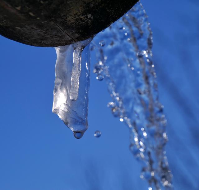 Nahaufnahme eines tlw. gefrorenen Wasserstrahles eines Brunnens