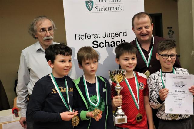 Gold für die VS Kumberg: Nikolaus Anhofer, Rafael Hofer, Felix Zangger, Filip Jazbisek und Trainer Anton Ostermann (re) mit dem neuen Schachpräsidenten Gerd Mitter (li)