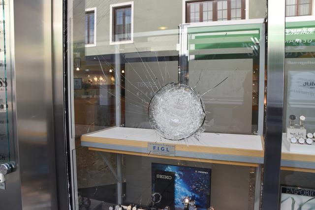 Mit der Hacke gegen die Auslage: Doch das Glas ist undurchdringlich.