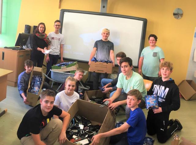 Gemeinsam mit der Religionslehrerin Gertrude Pfeiffer (stehend 1.v.l.) verpacken die Schüler die Handys für die Ö3-Aktion. | Foto: MMS Blindenmarkt