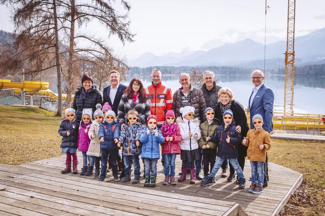 Strandbad Drobollach Lokalaugenschein: Die Kinder des Kindergarten Maria Gail mit von links KiGa-Leiterin Sonja Gmoser, Bürgermeister Günther Albel, Martina Zore vom KiGa Maria Gail, Strabag-Bauleiter Michael Wohlmuth, TVB-Villach-Vorsitzender Gerhard Stroitz, Oswald Guggenberger (Leiter Abfallwirtschaft und Bäderverwaltung im Magistrat), Vizebürgermeisterin Irene Hochstetter-Lackner und Walter Egger, Geschäftsgruppenleiter der städtischen Betriebe im Magistrat.